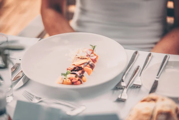 Bord met een luxe gerecht voor zittend persoon
